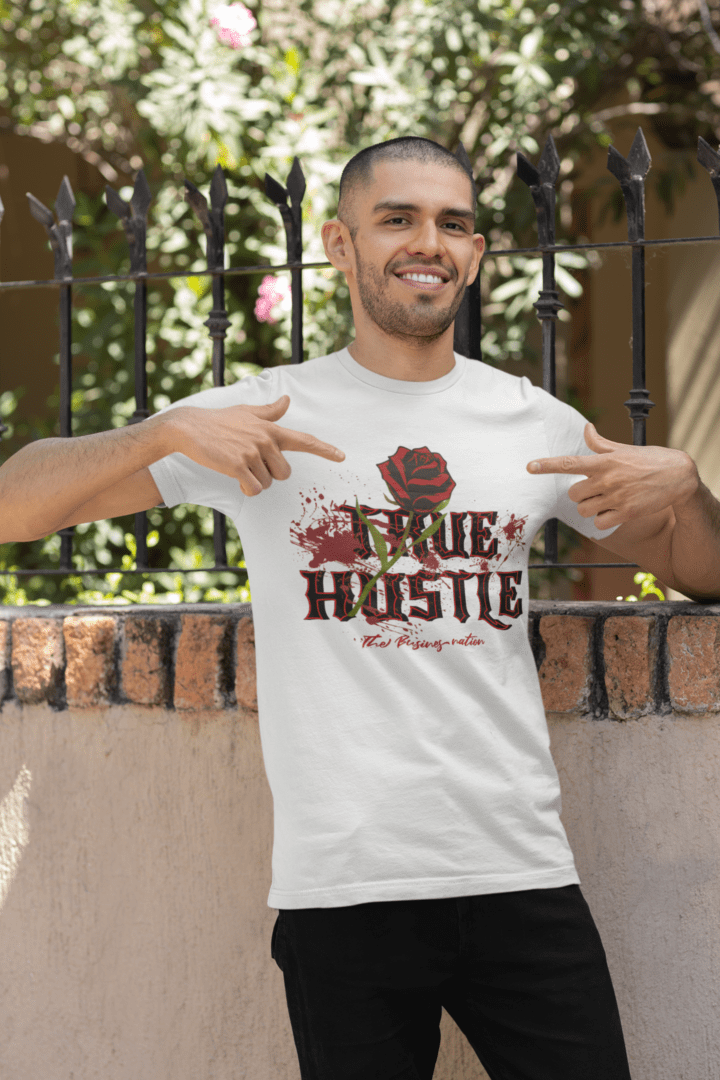 A man pointing to his t-shirt with the words " true hustle ".